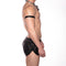 Man wearing black leather shorts and a choker on a white background