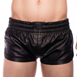 Black leather shorts worn by a person on a white background