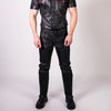 Man wearing a black leather outfit with red accents on a white background
