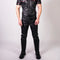 Man wearing a black leather outfit with red accents on a white background