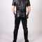 Person wearing a black leather outfit with red accents on a white background