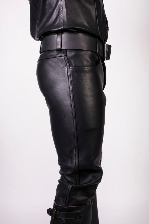 Black leather pants worn by a person on a white background