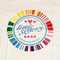 White t-shirt with 'little sisters' logo featuring rainbow colors and text on a white background